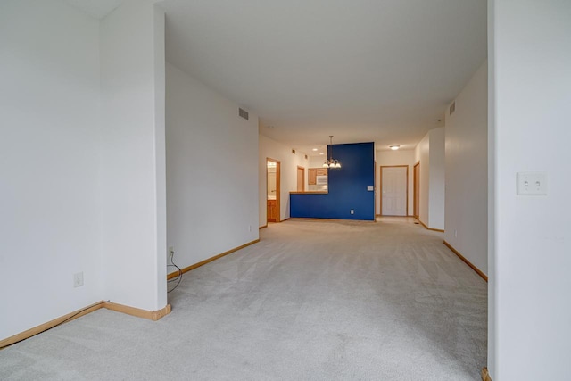 carpeted empty room with a chandelier