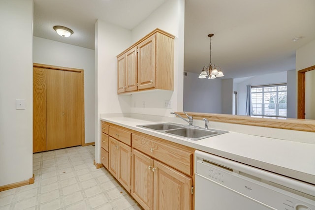 kitchen featuring dishwasher, hanging light fixtures, light brown cabinetry, and sink