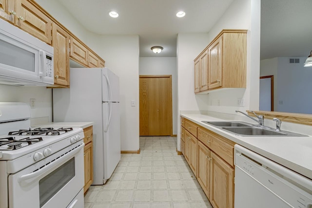 kitchen featuring light brown cabinetry, sink, and white appliances