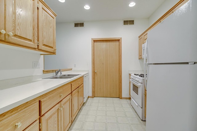 kitchen featuring light brown cabinets, white appliances, and sink