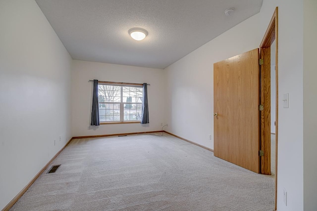 carpeted spare room with a textured ceiling