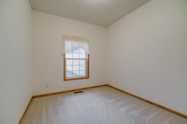 spare room featuring a textured ceiling and carpet