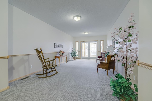 living area featuring french doors, carpet floors, a textured ceiling, and vaulted ceiling