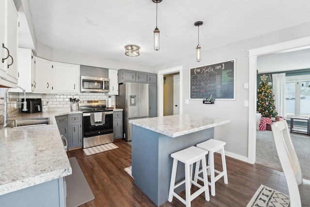 kitchen featuring a center island, stainless steel appliances, tasteful backsplash, dark hardwood / wood-style floors, and pendant lighting