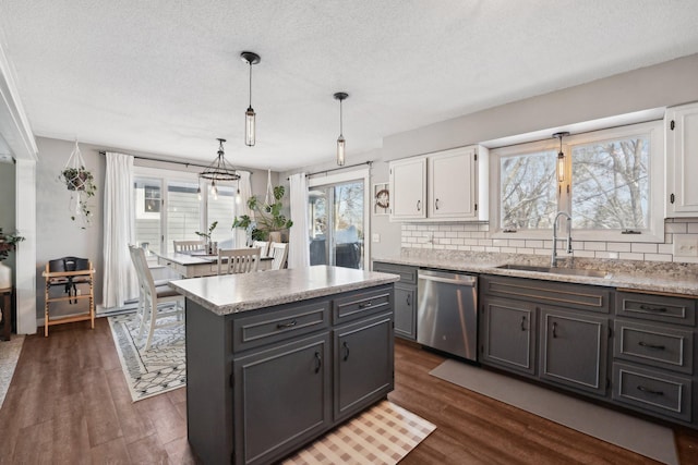 kitchen with decorative backsplash, a center island, decorative light fixtures, and stainless steel dishwasher