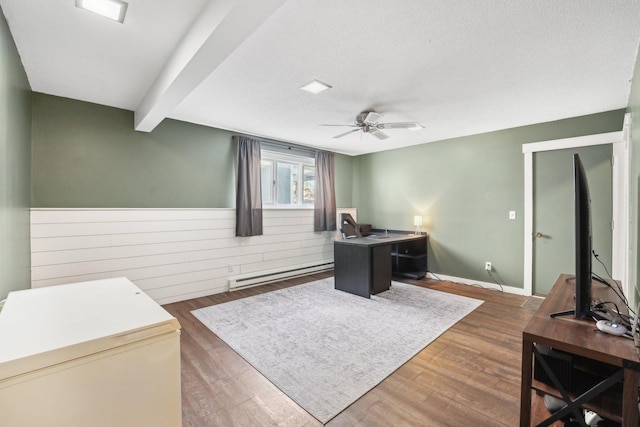 office area featuring beam ceiling, dark wood-type flooring, ceiling fan, and a baseboard heating unit