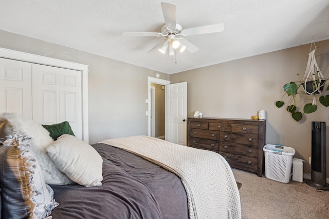 carpeted bedroom featuring a textured ceiling, a closet, and ceiling fan