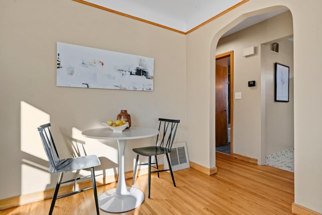 dining area with light hardwood / wood-style flooring and crown molding