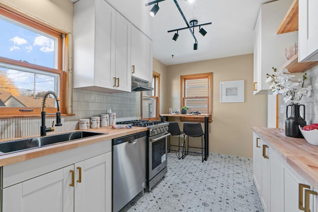 kitchen with white cabinets, wooden counters, and appliances with stainless steel finishes