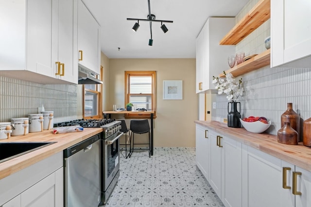 kitchen with white cabinets, wooden counters, extractor fan, and appliances with stainless steel finishes