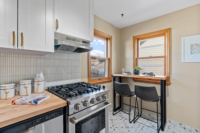 kitchen with wooden counters, range hood, backsplash, appliances with stainless steel finishes, and white cabinets