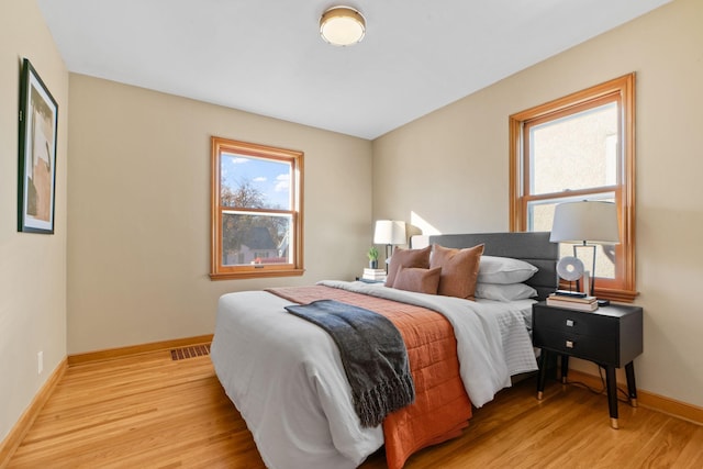 bedroom featuring multiple windows and light hardwood / wood-style flooring