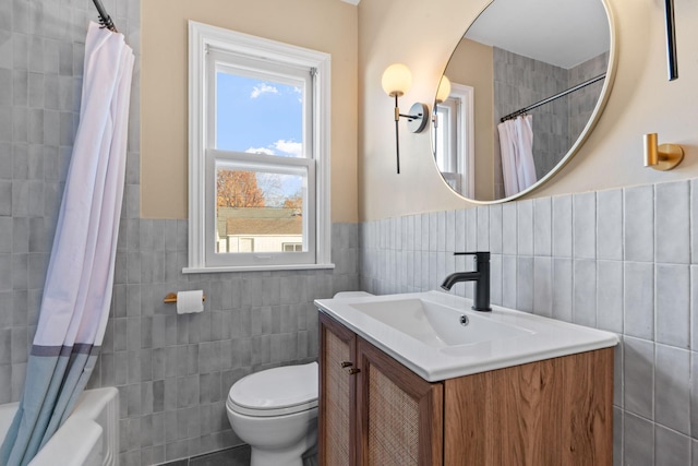 full bathroom with vanity, toilet, and tile walls