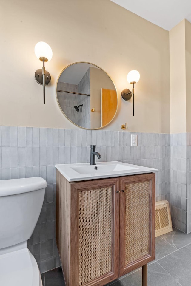 bathroom with vanity, tile patterned floors, toilet, and tile walls