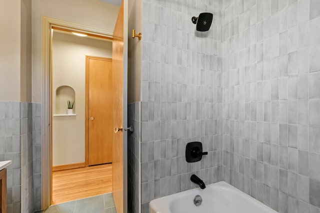 bathroom featuring vanity, tile patterned flooring, and tiled shower / bath