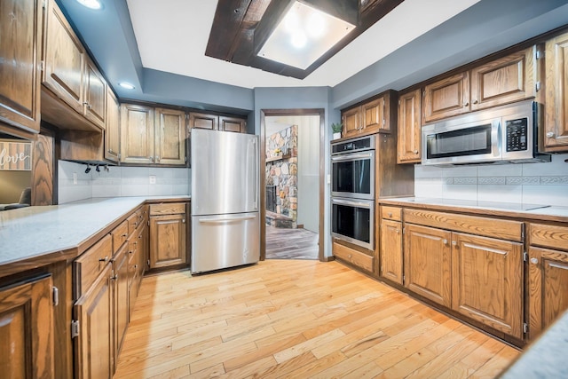 kitchen featuring light hardwood / wood-style flooring, backsplash, and stainless steel appliances