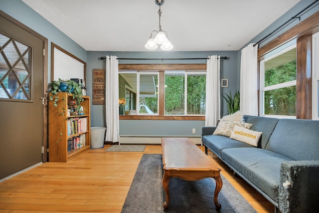 sitting room with plenty of natural light, an inviting chandelier, a baseboard radiator, and light hardwood / wood-style floors