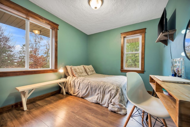 bedroom with hardwood / wood-style floors and a textured ceiling