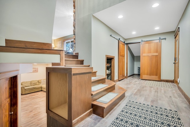 stairway with hardwood / wood-style flooring and a barn door