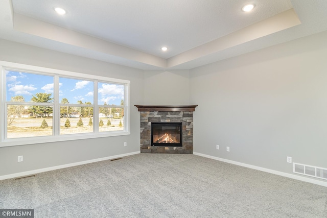 unfurnished living room with a fireplace, carpet floors, and a raised ceiling