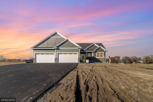 craftsman inspired home with board and batten siding, driveway, stone siding, and a garage