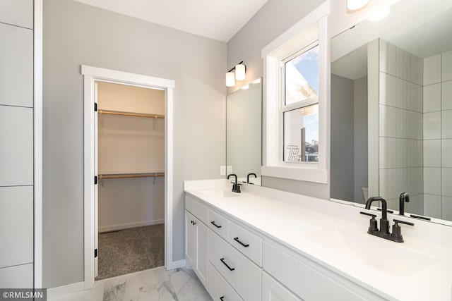 full bathroom with double vanity, a sink, marble finish floor, and a spacious closet