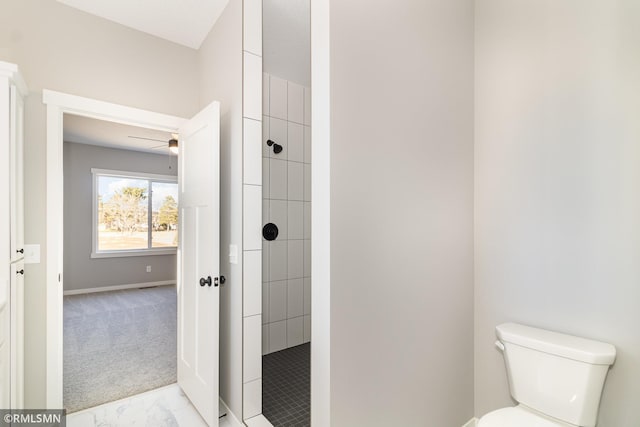 full bathroom with a ceiling fan, toilet, tiled shower, and marble finish floor