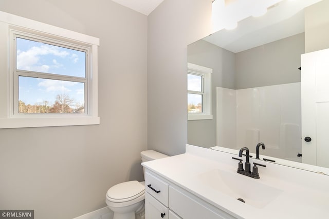 full bathroom with toilet, baseboards, a shower, and vanity