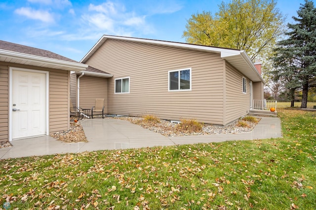 view of home's exterior with a yard and a patio area