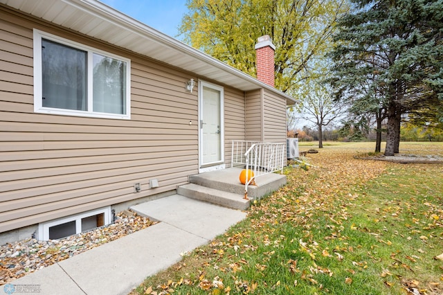 entrance to property featuring a lawn