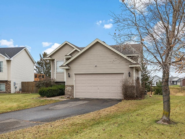 view of front of house with aphalt driveway, an attached garage, fence, stone siding, and a front lawn