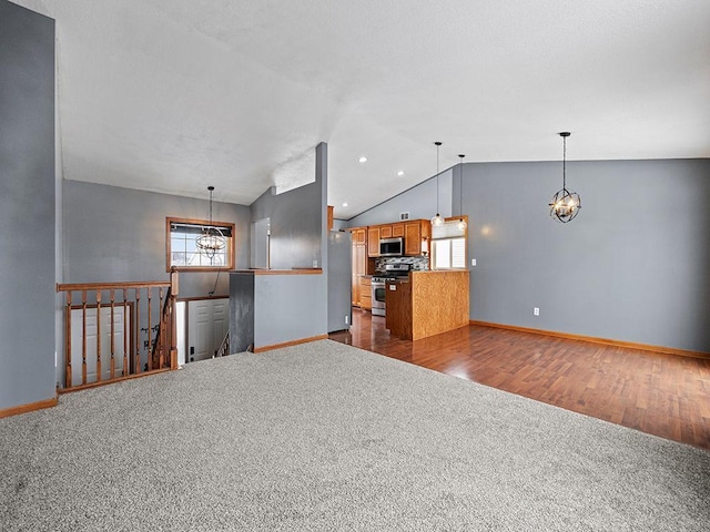 unfurnished living room with dark wood-type flooring, a chandelier, vaulted ceiling, and a wealth of natural light