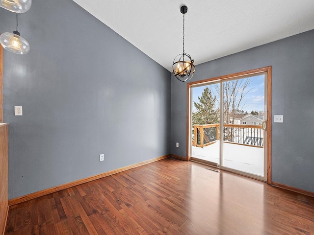 unfurnished dining area with an inviting chandelier, visible vents, baseboards, and wood finished floors