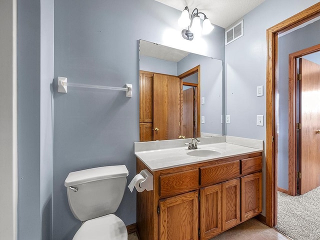 bathroom featuring toilet, visible vents, and vanity