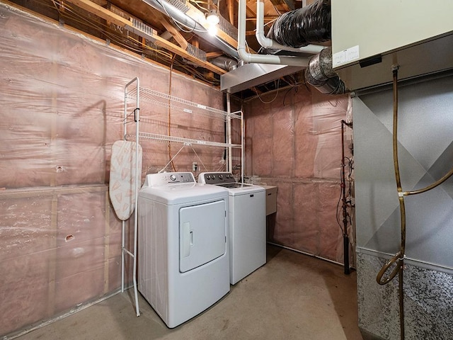 laundry area with laundry area, washer and clothes dryer, and heating unit