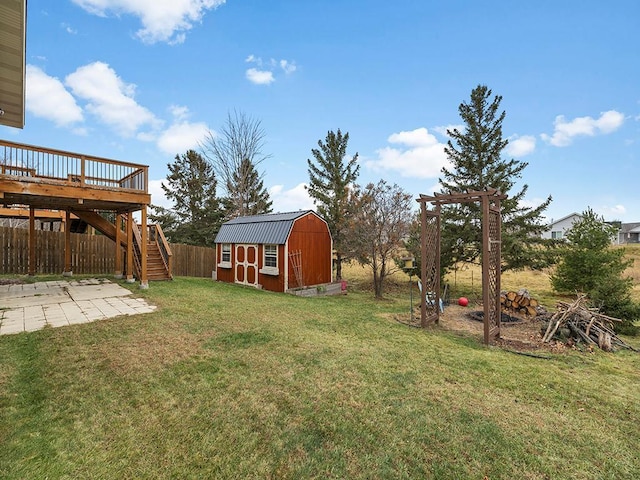 view of yard featuring an outbuilding, a storage shed, fence, stairway, and a patio area