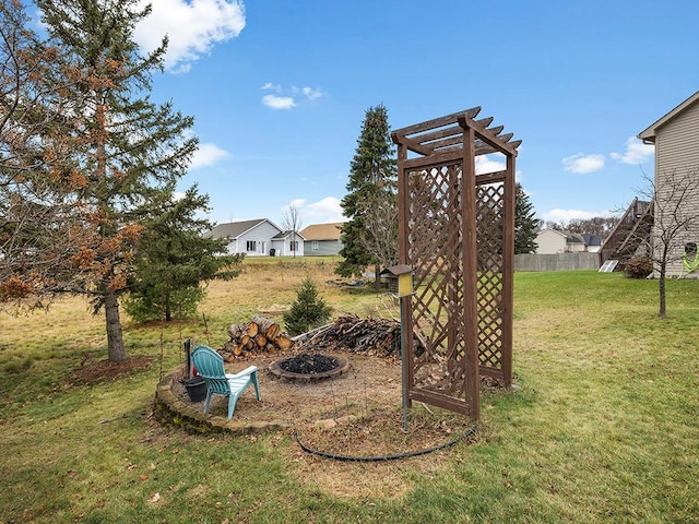 view of yard featuring an outdoor fire pit and fence