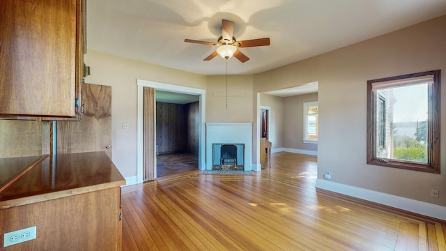 unfurnished living room with wood-type flooring and ceiling fan