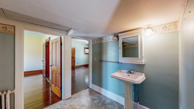 bathroom with radiator heating unit and wood-type flooring