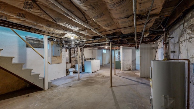 basement featuring washing machine and clothes dryer, water heater, and electric panel