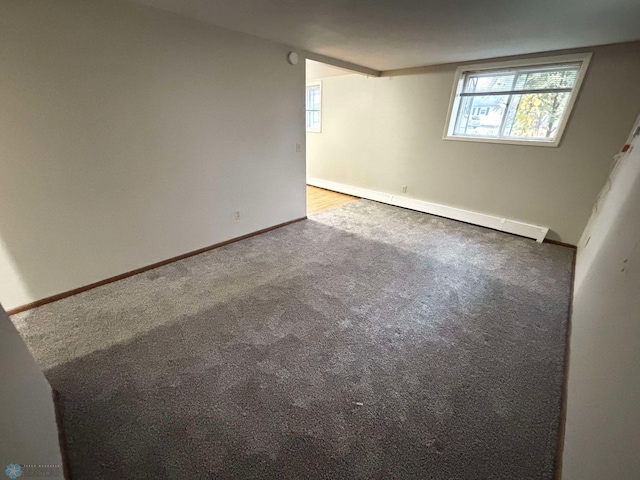 unfurnished room with carpet flooring and a baseboard heating unit