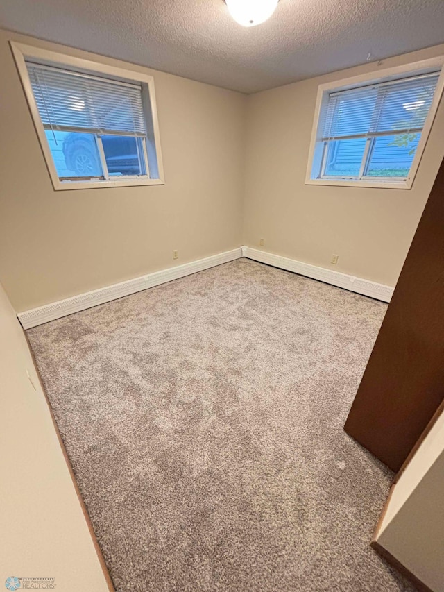 empty room with a textured ceiling and carpet