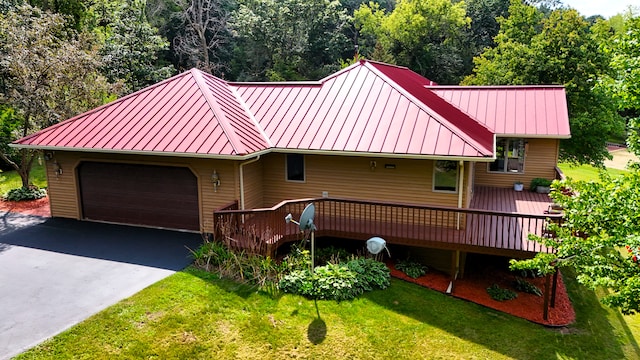 view of front of home featuring a garage, a wooden deck, and a front yard