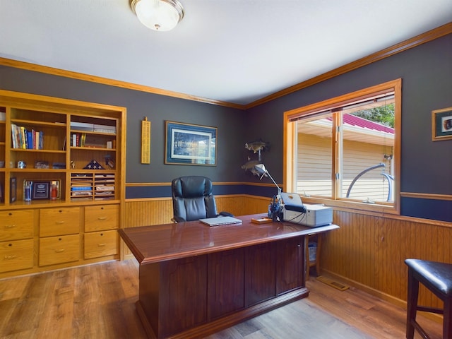 office area with wood walls, wood-type flooring, and crown molding