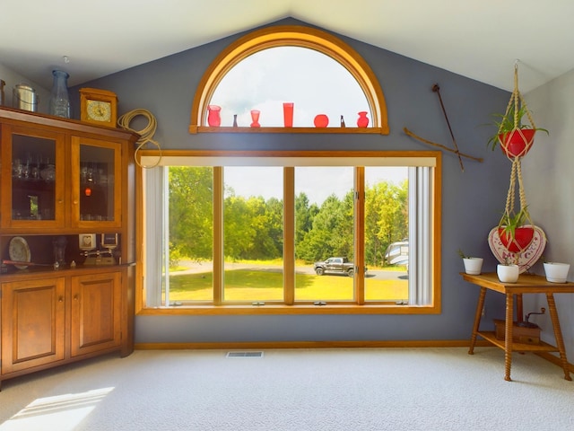 carpeted dining area featuring lofted ceiling