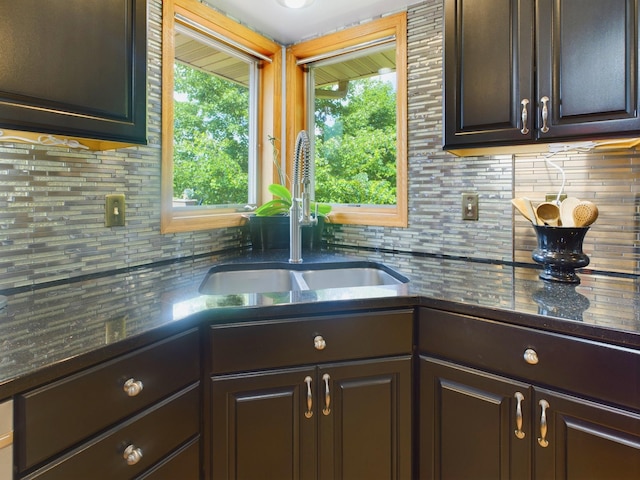 kitchen featuring dark brown cabinetry, sink, and decorative backsplash