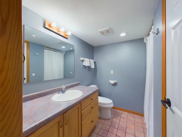 bathroom with toilet, vanity, a textured ceiling, and tile patterned flooring