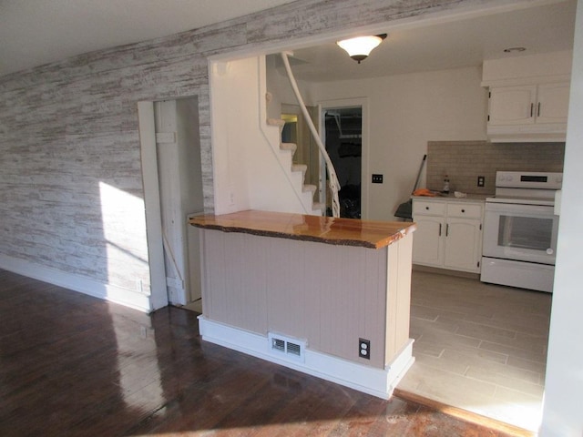 kitchen featuring white cabinetry, kitchen peninsula, white range with electric cooktop, and hardwood / wood-style flooring