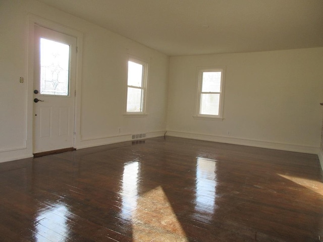 interior space with a wealth of natural light and dark hardwood / wood-style floors