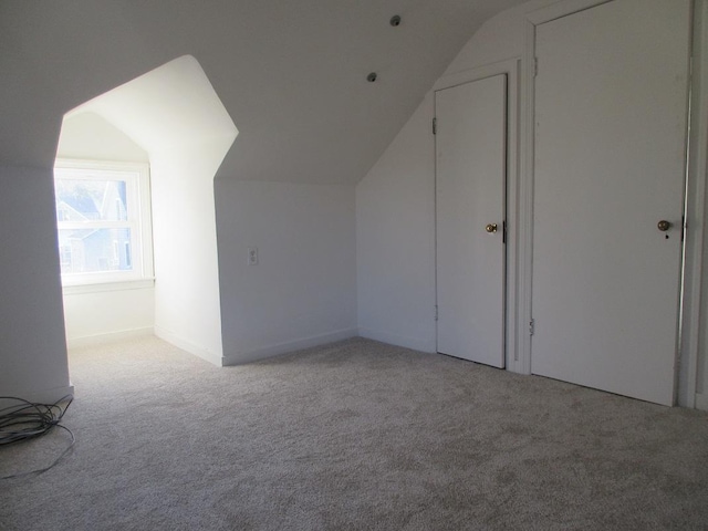 bonus room with light carpet and lofted ceiling